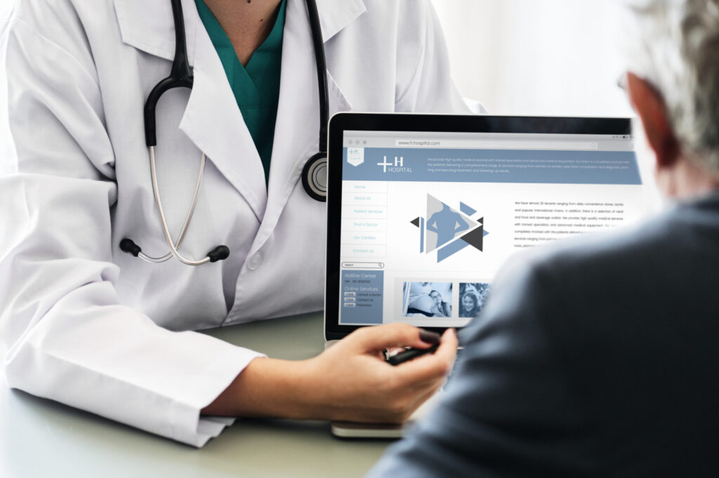 Doctor discussing a healthcare website with a patient, demonstrating medical website optimization, healthcare digital marketing, and urgent care SEO services.